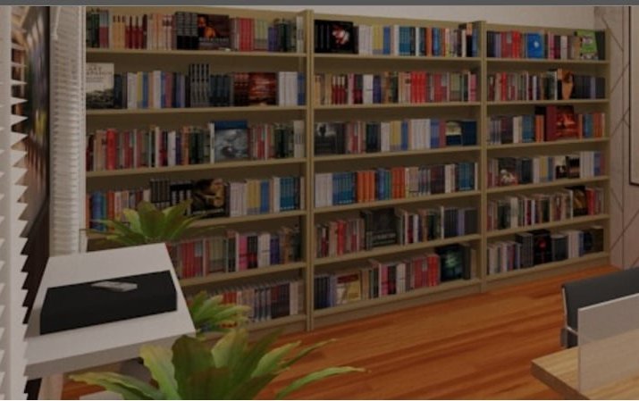 The reading room of the Abdulkhader Jainallaudeen Memorial Library, with full-height bookshelves and a long study table.
